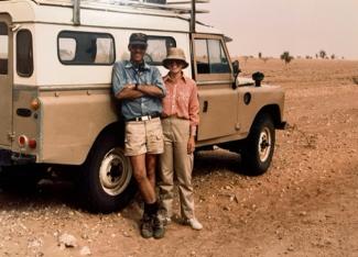 Drs. David and Dorinda Dallmeyer in front of a land rover in the Sahara Desert